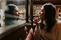 Asian woman applying lipstick, beauty product