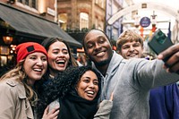 Happy diverse friends taking selfies in the city