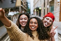 Happy girl friends selfie in city, diverse people