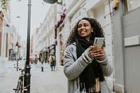 Woman holding mobile phone, walking in the city