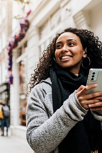 Woman holding mobile phone, walking in the city