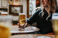 Woman sitting with beer glass in a pub