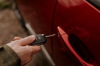 Man hand opening car door with key photo