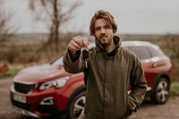 Man on road trip, showing car key photo