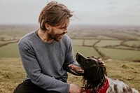 Man & dog sitting on hill photo