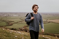 Man wearing long sleeve shirt, walking on hill