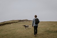 Man walking dog on hill photo