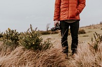 Photographer wearing jacket, holding camera, nature photo