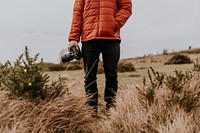 Photographer wearing jacket, holding camera, nature photo