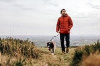 Man walking dog on hill photo