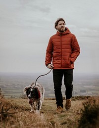 Man walking dog on hill photo