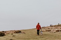 Man walking dog on hill photo