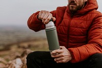 Drinking coffee from a thermos, while hiking