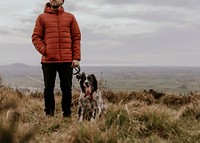 Man walking dog on hill photo