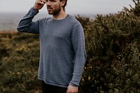 Man wearing long sleeve shirt, walking on hill