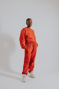 Woman in orange sweater, sweat pants, street fashion