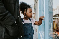 Little girl window shopping with her mum