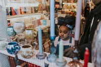 Little girl looking at antique, shopping with mum