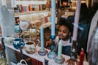 Little girl looking at antique, shopping with mum