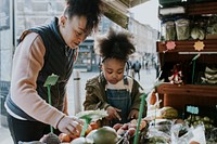 Mother and daughter picking vegetable at fresh market