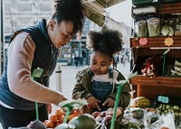 Mother and daughter picking vegetable at fresh market