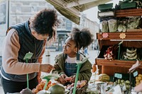 Mother and daughter picking vegetable at fresh market