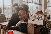 Little girl showing her drawing at a restaurant