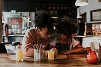 Mum drawing with daughter at a restaurant