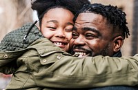 Daughter hugging her dad, African-American family photo