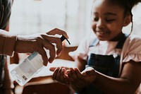 Kid using hand sanitizer, COVID-19 photo