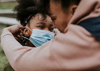 Mother putting mask on child, COVID-19 photo