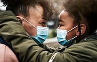 Mother and child putting on mask, COVID-19 photo