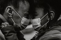 Mother and child putting on mask, black & white photo