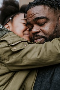 Daughter hugging her dad, African-American family photo