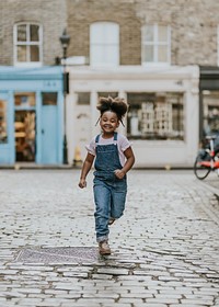 Happy African-American girl running on the street