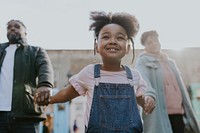 Happy black family walking daughter in city