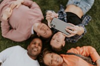 Happy diverse friends taking selfies in a park