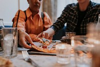 Diverse people grabbing pizza slice