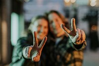 Couple showing peace signs, blurry photo