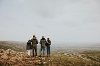 Happy family hiking on mountain, rear view