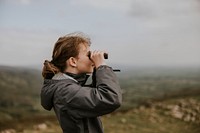 Girl using binoculars while hiking