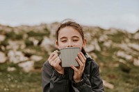 Girl drinking from mug, outdoor photo