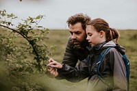 Father & daughter looking at leaf