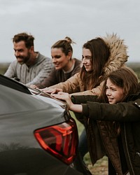 Family pushing broken car photo