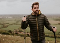 Man wearing jacket, holding hiking pole