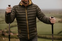 Man wearing jacket, holding hiking pole