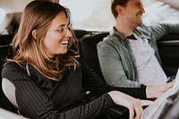 Smiling couple looking at map in car photo