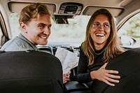 Smiling couple looking at back seat photo