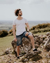 Confident man standing on hill, men's fashion photo