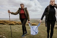 Female hikers holding cooler bag together, outdoor activity photo